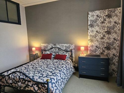 - une chambre dotée d'un lit bleu et blanc avec 2 oreillers rouges dans l'établissement Le central 310, à Vittel