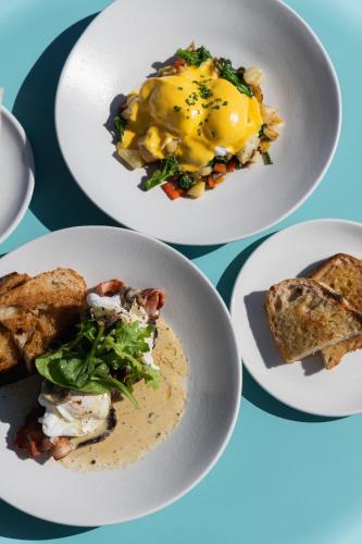 three plates of food on a table at Latitude Aparthotel by Totalstay in Cape Town