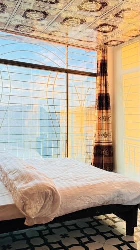 a bed in a room with a large window at Green view guest house nathiagali by room in Nathia Gali
