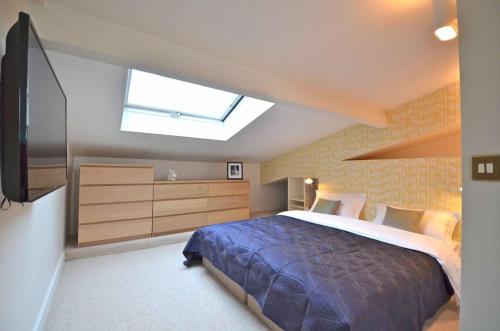 - une chambre avec un grand lit et une lucarne dans l'établissement Grande Pomme, à Paris