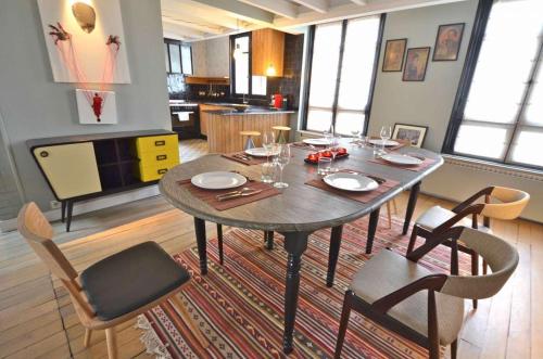une salle à manger avec une table et quelques chaises dans l'établissement Grande Pomme, à Paris