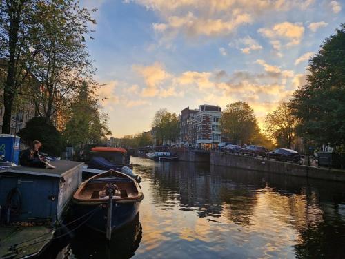 a boat is docked on a river in a city at Pantheos Top Houseboat in Amsterdam