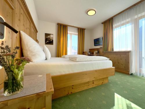 a bedroom with a bed and a vase of flowers at Landhaus Lechthaler in Sankt Anton am Arlberg