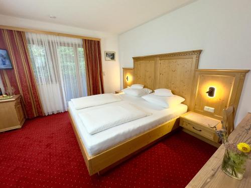 a bedroom with a large bed with white sheets and pillows at Landhaus Lechthaler in Sankt Anton am Arlberg