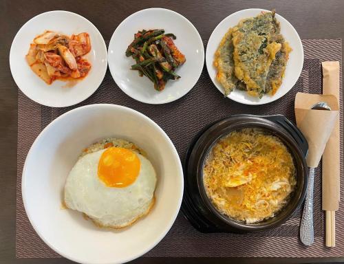 a table topped with plates of food with eggs and vegetables at Paragon Hotel PMH in Ho Chi Minh City