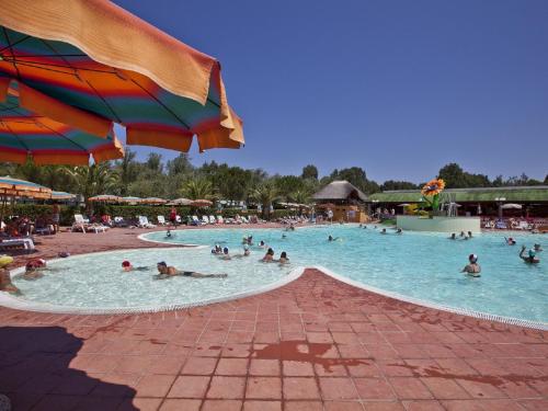a group of people in a pool at a resort at Holiday Home Happy Superior by Interhome in Marina di Bibbona