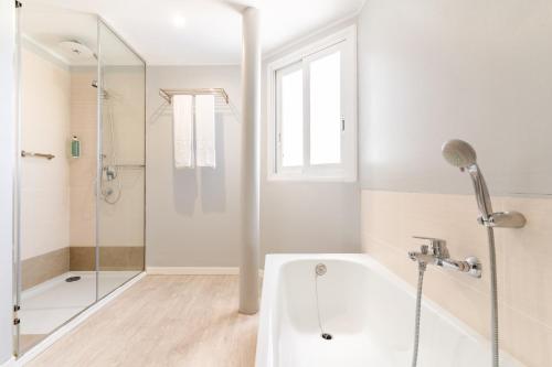 a white bathroom with a tub and a shower at HOVIMA Costa Adeje - For Cool Adults in Adeje