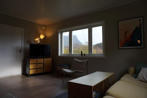 a living room with a couch and a table and a window at Koselig hus ved Kabelvågmarken in Kabelvåg