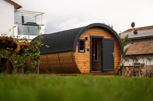 a small wooden building with a black roof at Campingfass Mündlein in Sommerhausen