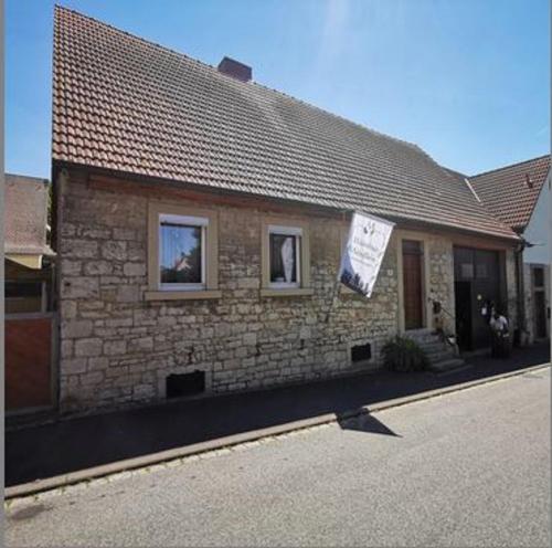 a brick house with two windows and a sign on it at Campingfass Mündlein in Sommerhausen