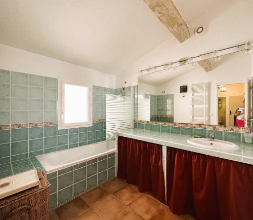 une salle de bain avec une baignoire et un lavabo et une baignoire dans l'établissement Villa Myosotis pour 8 personnes avec piscine chauffée et vue mer à La Londe-Les-Maures, à La Londe-les-Maures