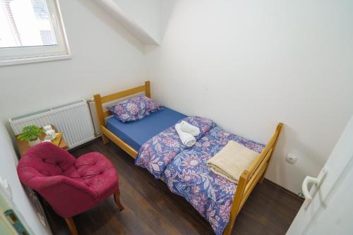 a small bedroom with a bed and a chair at Konačište Zlatiborski Put in Užice