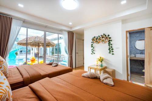 two beds in a room with a pool at Cloud9 Pool Villa in Cha Am