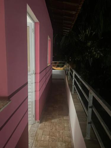a pink building with a hallway with a window at Casas de Temporada Condomínio Lene Andrade in Valença