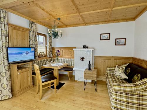 a living room with a table and a tv at Landhaus Lechthaler in Sankt Anton am Arlberg