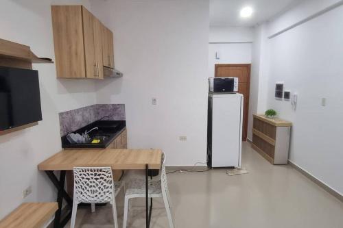 a kitchen with a wooden table and a refrigerator at Mono ambiente costanera in Encarnación