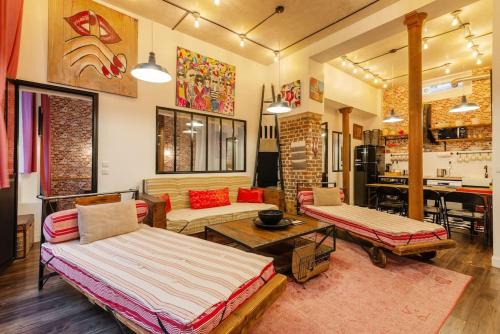 un salon avec deux lits et une table dans l'établissement Montmartre Rue des Martyrs Loft with AC, 4-7 PEO, à Paris