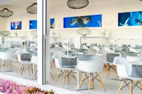 a room with white chairs and tables and a window at HOVIMA Costa Adeje - For Cool Adults in Adeje