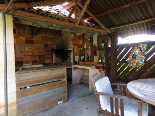 Il comprend une cuisine équipée d'une cuisinière et d'un comptoir avec une table. dans l'établissement Chambres d'hotes du Domaine Capiet, à Courpiac