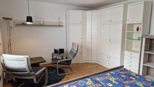 a bedroom with white cabinets and two chairs and a bed at Ferienwohnung Bad Neuenahr in Bad Neuenahr-Ahrweiler