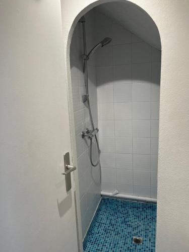 La salle de bains est pourvue d'une douche et de carrelage bleu. dans l'établissement studio tout equipe, à Rueil-Malmaison