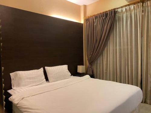 1 dormitorio con 1 cama blanca grande y cabecero negro en Home to my heart B56, en Jomtien Beach