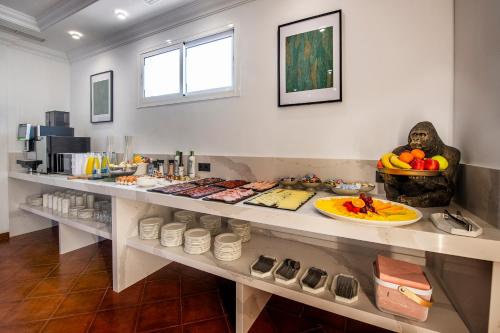a room with a counter with plates of food at Hotel Tamisa Golf in Mijas