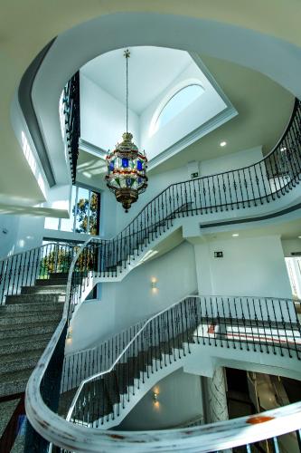a spiral staircase in a building with a chandelier at Hotel Tamisa Golf in Mijas