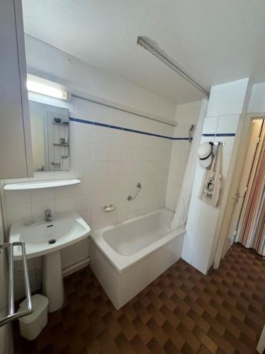 une salle de bain avec une baignoire, un lavabo et des toilettes dans l'établissement Appartement - Cap d'Agde, au Cap d'Agde