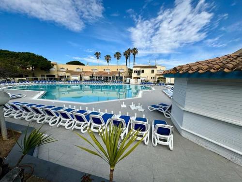 - une piscine avec des chaises longues bleues et blanches dans l'établissement Appartement - Cap d'Agde, au Cap d'Agde