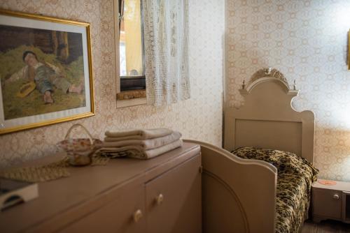 a bedroom with a bed and a dresser with a mirror at Brkin salaš in Čenej