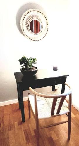 a black table with a chair and a mirror at Uroczy dom na ładnym podwarszawskim osiedlu in Michałowice