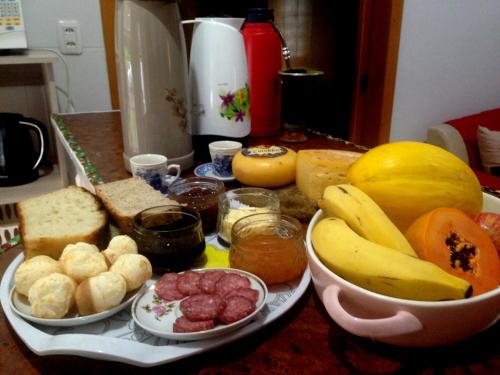 een tafel met verschillende soorten brood en fruit bij Kantinho da Serra in Nova Petrópolis