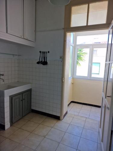 une cuisine vide avec un évier et une fenêtre dans l'établissement Chez Michel, à Marseille