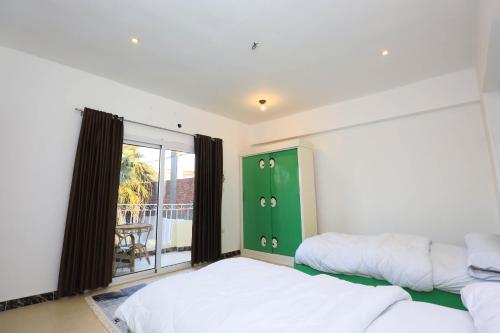 a bedroom with two beds and a green cabinet at Moka Gust House in Luxor