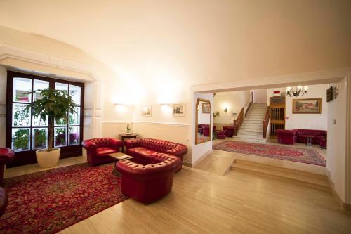 a living room with red furniture and a staircase at Hotel Gran Duca in Livorno