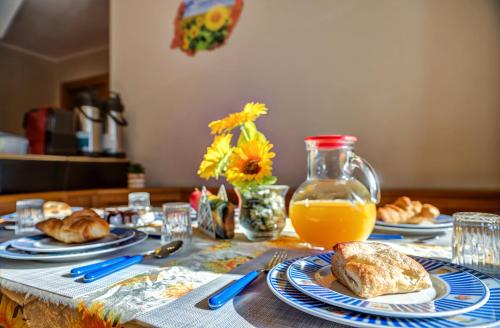 a table with plates of food and a jug of orange juice at Il Girasole Bed and Breakfast in Donnas