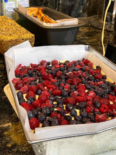 a pan filled with blueberries and raspberries at Hotel y Cabañas Casa de Piedra in Trevelin