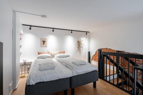 a bedroom with a large bed with white sheets at Stylish Loft next to City Center & Lake Pyhäjärvi in Tampere