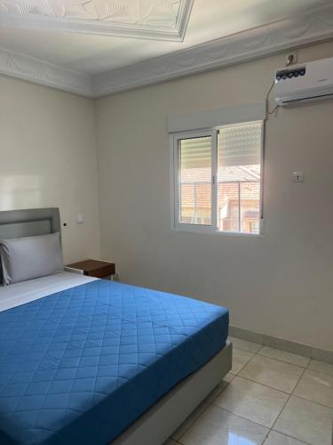 a bedroom with a blue bed and a window at MAG Palace Hotel in Bissau