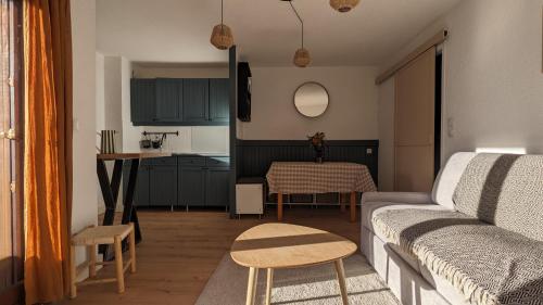 un salon avec un canapé et une table dans l'établissement Cosy studio - vue imprenable sur les montagnes, à Embrun