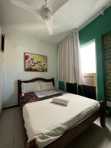 a bedroom with a bed with a ceiling fan at CasAMARelo Hostel in Salvador