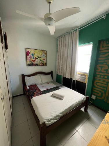 a bedroom with a bed with a ceiling fan at CasAMARelo Hostel in Salvador