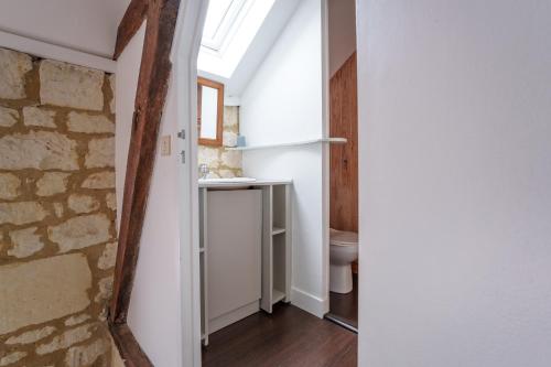 a bathroom with a toilet and a window at Belle demeure avec piscine à Bourgueuil 5 ch/10 p in Bourgueil