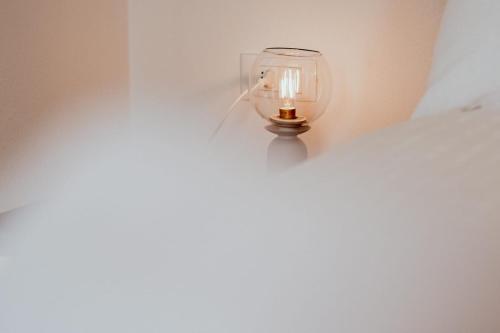 a light hanging from a wall with a candle at Appartamento Dolomiti Dream 1 in Falcade