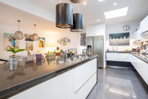 a kitchen with white cabinets and a counter top at Grand Loft plein centre Concarneau in Concarneau