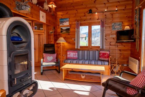 - un salon avec un canapé et une télévision dans une cabane en rondins dans l'établissement Chalet Terrasse Plein Sud, Cheminée, Ski-Rando, Nature & Village, Animaux admis, Parking, à La Bresse