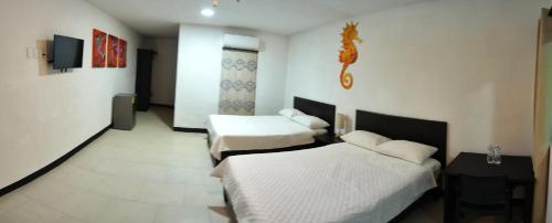 a hotel room with two beds and a television at Hotel Villa Capricho in Ciudad Madero