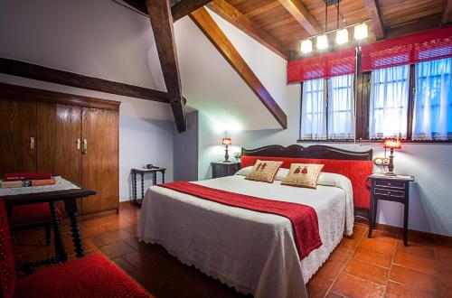 een slaapkamer met een groot bed en een rode deken bij Casa de Aldea Riosol in Cangas de Onís