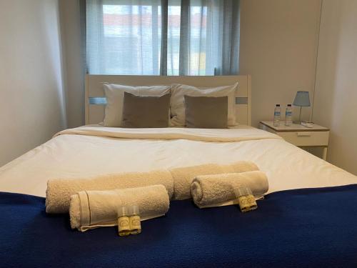 a bedroom with a large bed with two towels on it at Barreiro Central Apartment in Barreiro